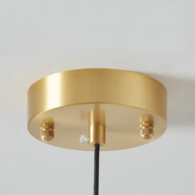 Modern brass and amber glass pendant light with gold circular ceiling fixture and copper bauhaus led mounting screws