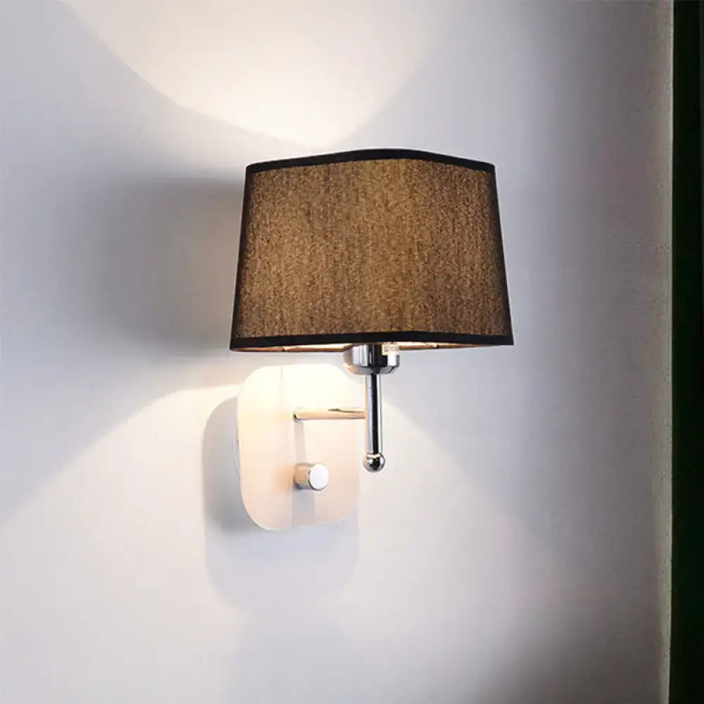 Modern wall sconce lighting with a textured brown fabric shade and polished chrome accents for bedroom use