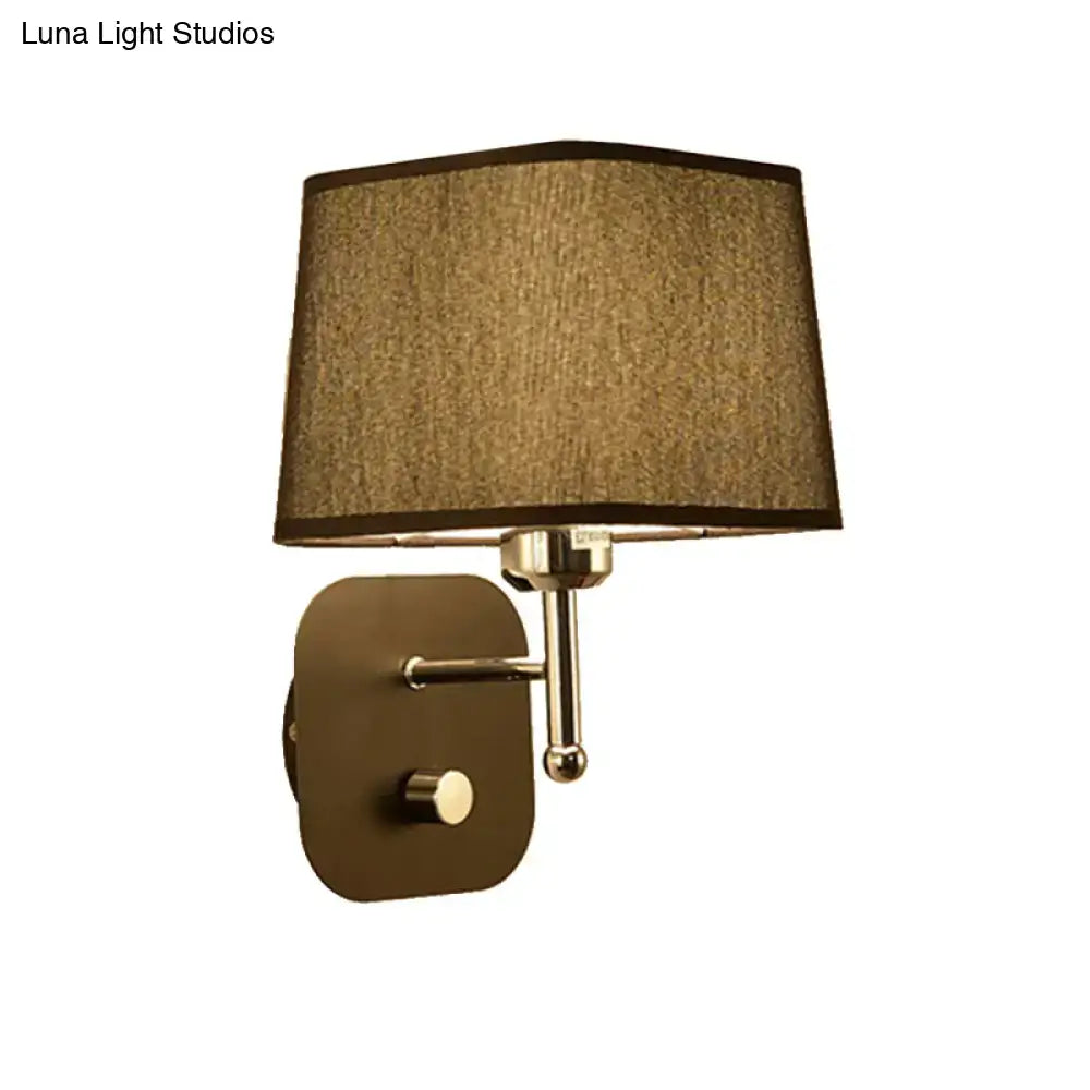 Modern brass and beige linen wall sconce lighting with bronze finish and taupe fabric shade for bedroom use