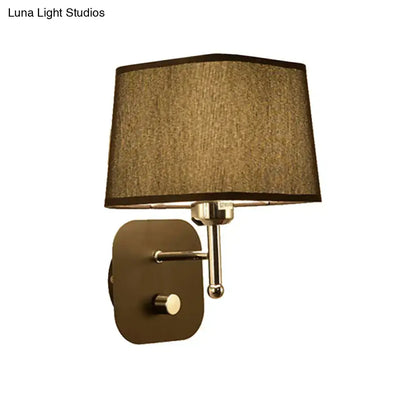 Modern brass and beige linen wall sconce lighting with bronze finish and taupe fabric shade for bedroom use