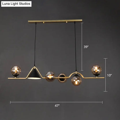 Modern brass and black geometric pendant light with spherical glass bulbs in gold metal ball hanging island design