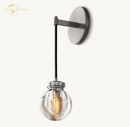 Modern brass and black crystal led wall sconce with brushed nickel base, black arm, and ribbed glass shade for bedroom lighting