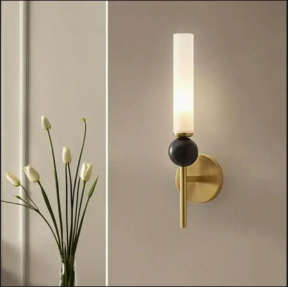Modern brass and black decorbites foyer hallway lamp with frosted glass cylinder and black spherical accent wall sconce