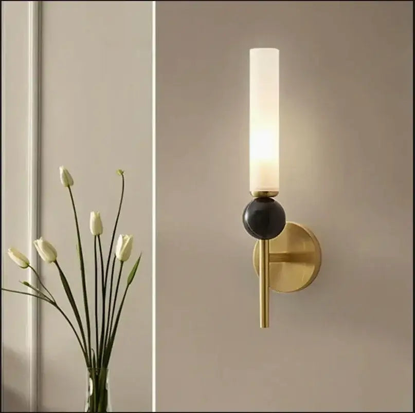 Modern brass and black decorbites foyer hallway lamp with frosted glass cylinder and black spherical accent wall sconce