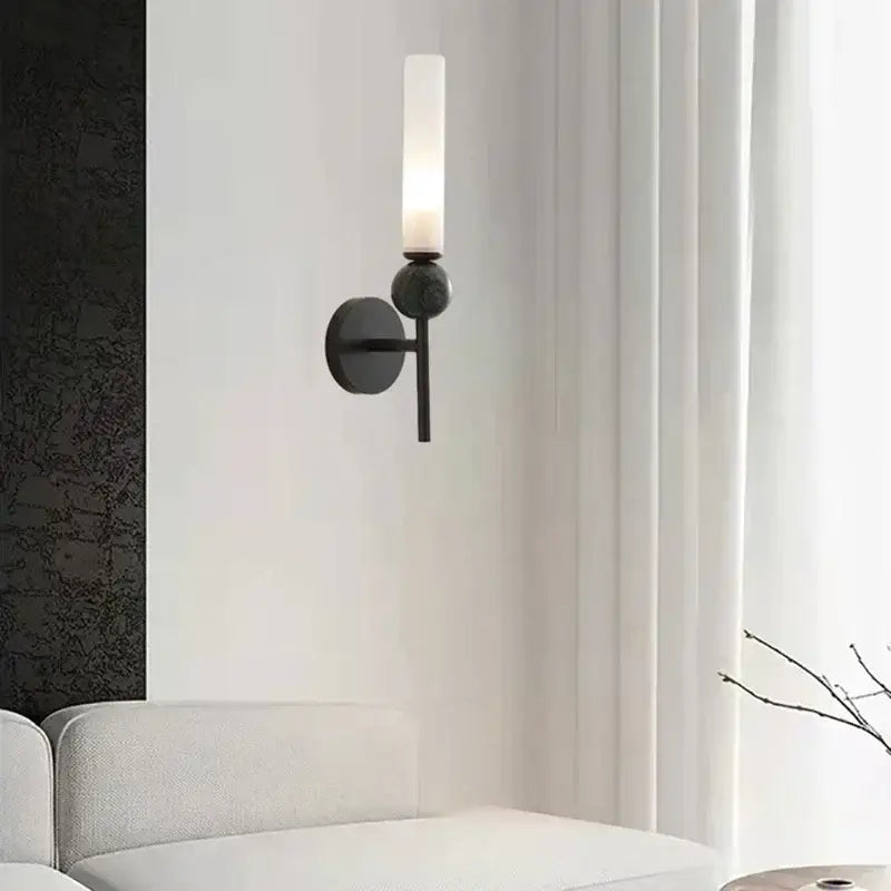 Modern black metal wall sconce with frosted glass cylinder and spherical accent for decorbites foyer hallway lamp