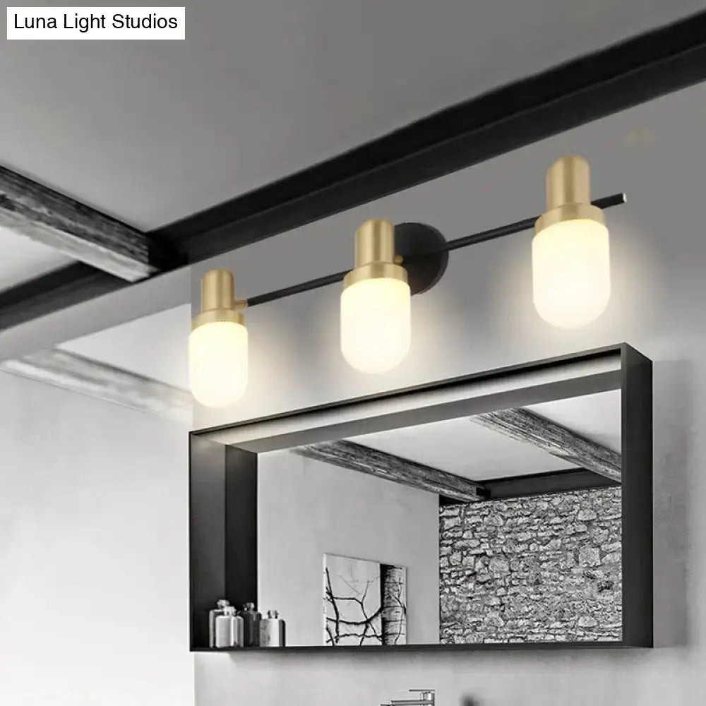 Modern brass and black glass sconce light with brushed gold cylindrical shades and black metal arms for bedroom wall lamp