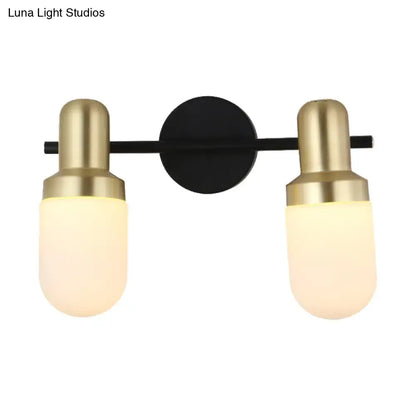 Modern brass and black glass sconce light with brushed brass fixtures and frosted glass shades on black metal bar