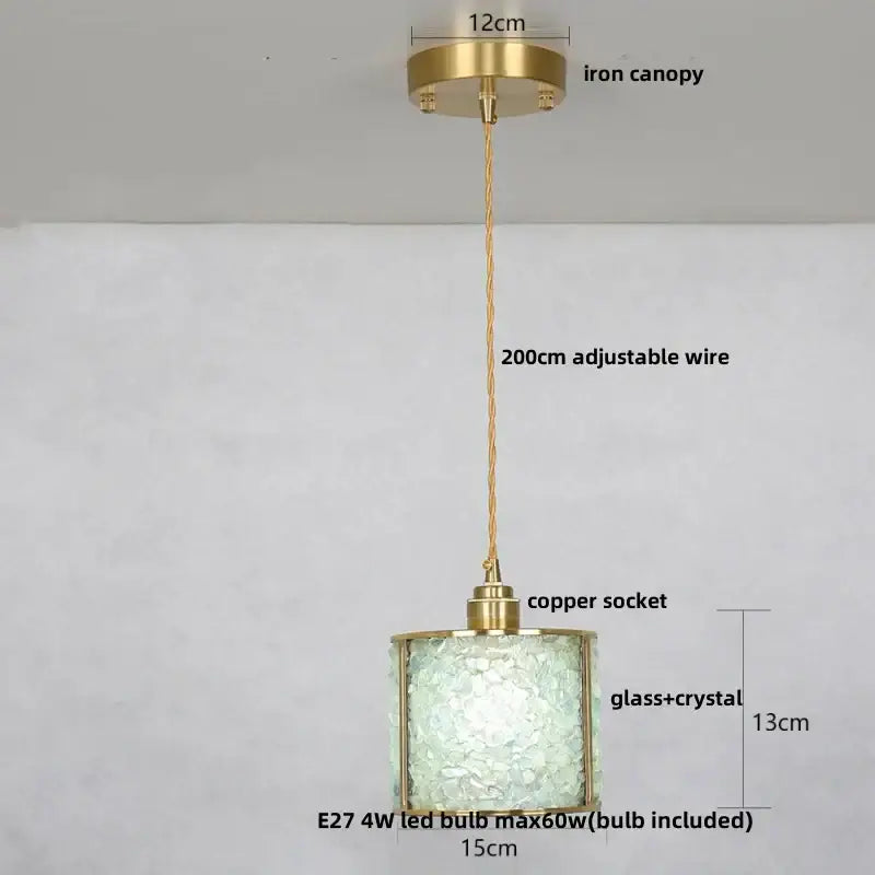 Modern brass and blue crystal glass pendant light fixture with cylindrical brass frame and intricate shade for kitchen