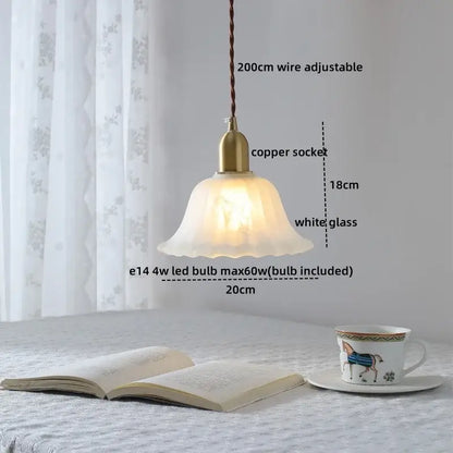 A warm glowing modern chandelier pendant light with brass copper socket and white glass shade for dining room