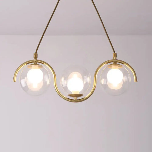 Modern brass and clear glass globe pendant light with three clear glass shades and adjustable chain cord length fixture width