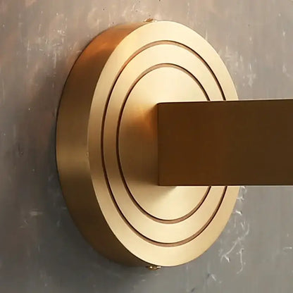 Brass-finished wall-mounted towel rack with concentric circular rings and square bar in decorbites copper wooden frame wall light