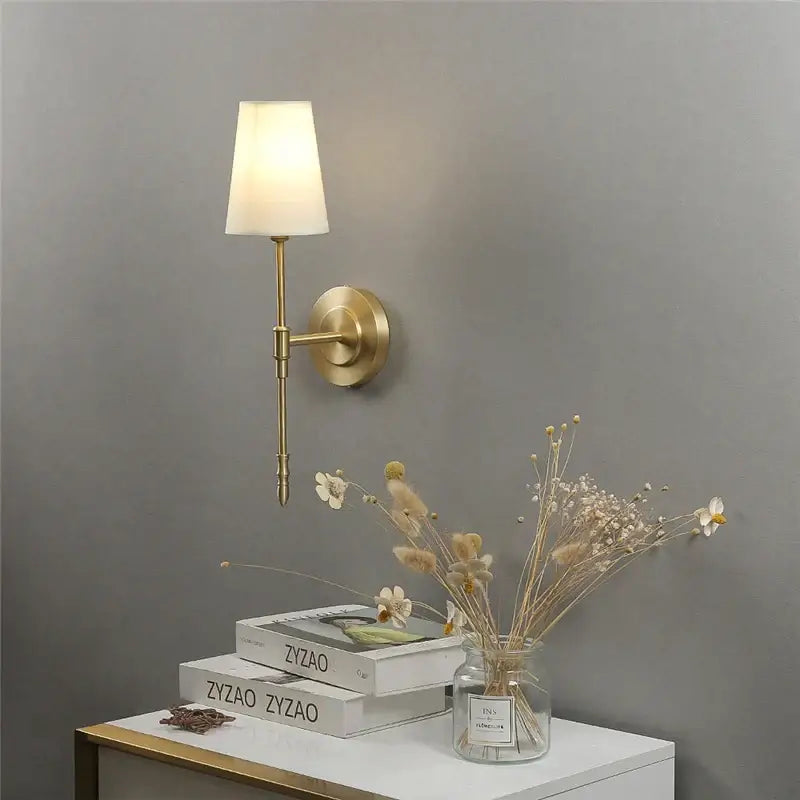 Modern brass and cream fabric led wall lamps featuring a brass finish and off-white fabric shade for bedroom wall lamps