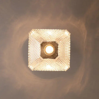 Modern brass and diamond glass pendant lamp with crystal-encrusted square fixture emitting warm glow for living room