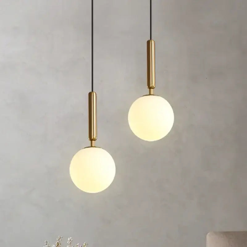 Two modern brass and frosted glass ball pendant lights with polished fixtures for dining room decorbites glass ball decor