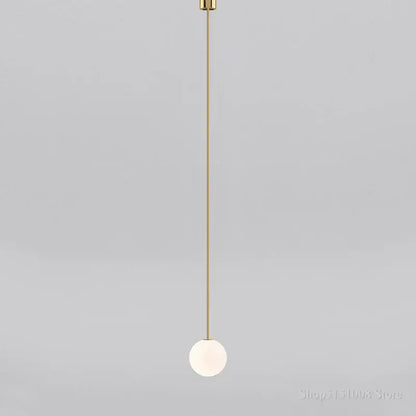Minimalist modern brass pendant light with frosted glass ball and slender rod for elegant kitchen lighting decorbites glass ball