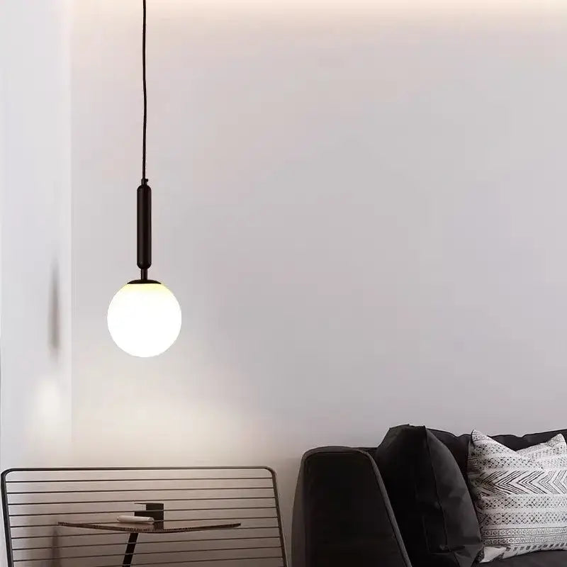 Modern brass and frosted glass pendant light with spherical frosted glass bulb and matte black fixture chandelier pendant light
