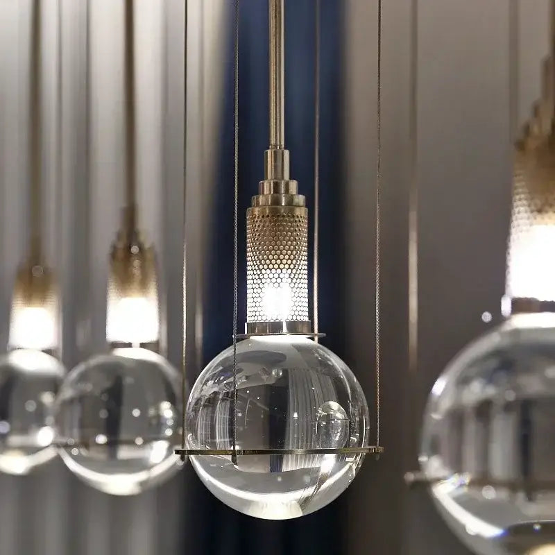 Modern brass and glass crystal ball led pendant light with clear globe and textured brass-finished metal top for dining room decorbites pendant light