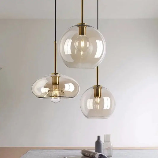 Three modern glass pendant lights with brass accents and iron finish cord pendant installation for dining room