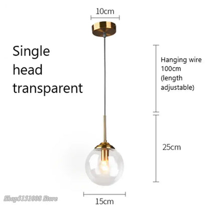 Modern brass and glass pendant lights featuring a transparent glass pendant with gold-toned fixture and adjustable wire