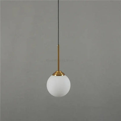 Modern brass and glass pendant light with frosted white glass globe for kitchen and dining room pendant lights