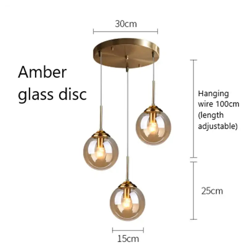 Modern brass and glass pendant lights featuring amber glass globe pendant lights with adjustable brass fixtures
