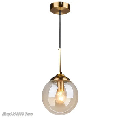 Modern brass and glass pendant light with spherical translucent globe ideal for kitchen and dining room lighting