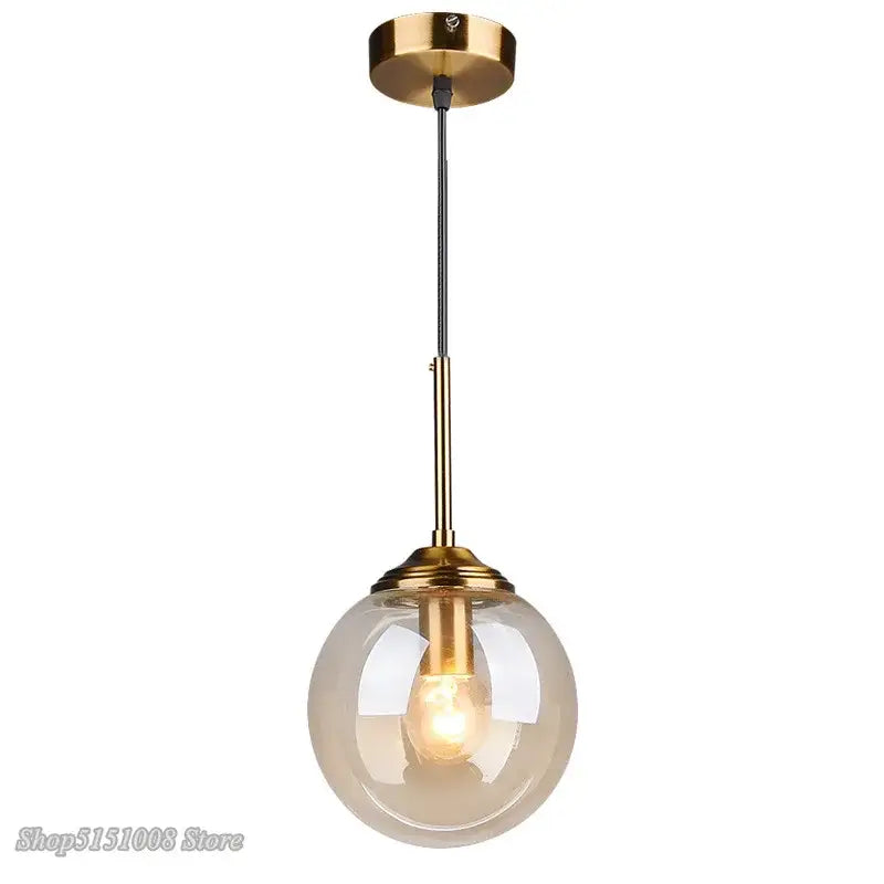 Modern brass and glass pendant lights featuring a spherical translucent glass pendant for kitchen and dining room