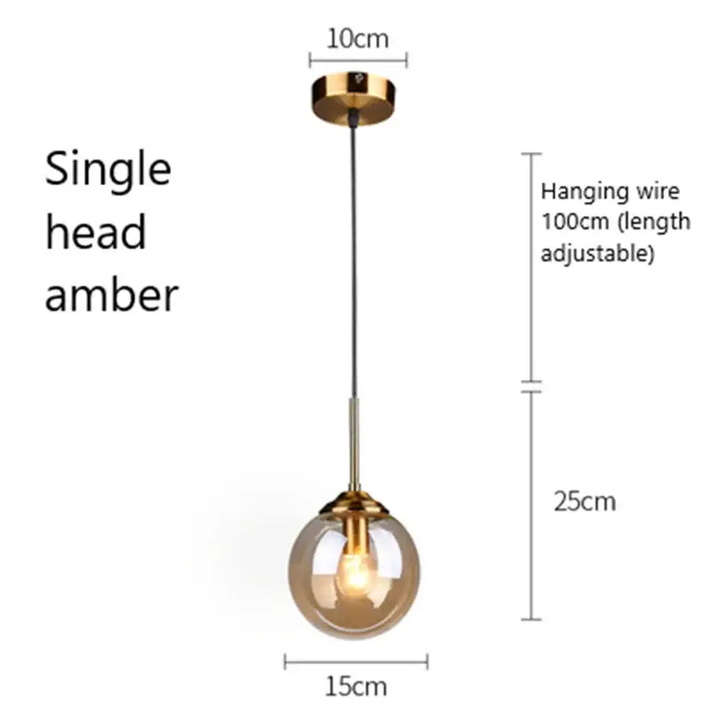 A single head modern brass and glass pendant light with an amber glass globe for kitchen and dining room use