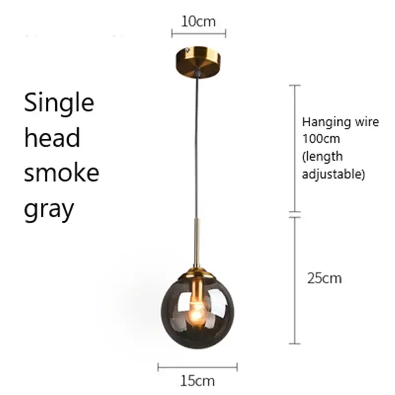 A sleek single-head glass pendant light with a smoke gray globe and gold-toned brass accents for kitchen use