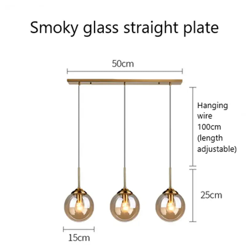 Modern brass and glass pendant lights with smoky glass pendant globes and metal accents for kitchen or dining room