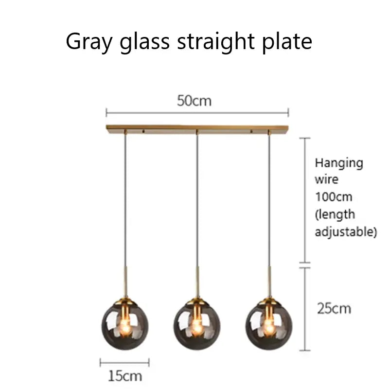 Modern brass and glass pendant lights featuring three sleek gray glass pendant spheres for kitchen dining room lighting