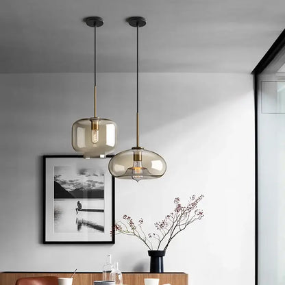 Two modern pendant lights with smoked glass shades and brass accents for kitchen dining room chandelier use