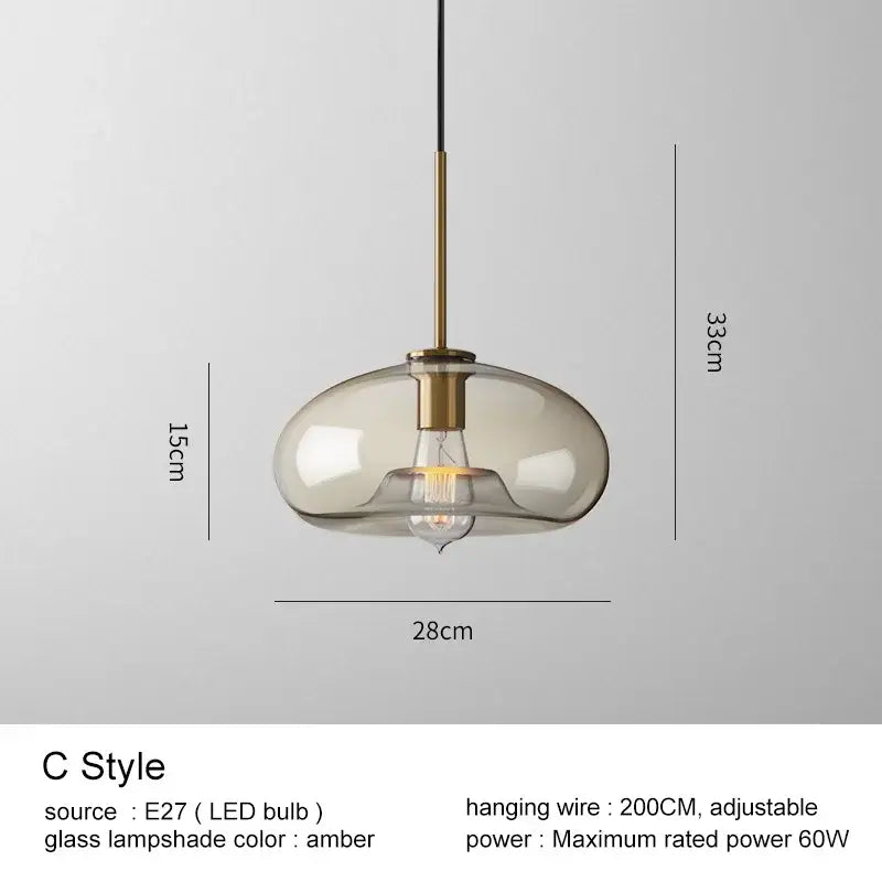 Modern brass and amber-tinted glass pendant lights with black wire for kitchen and dining room chandelier lighting