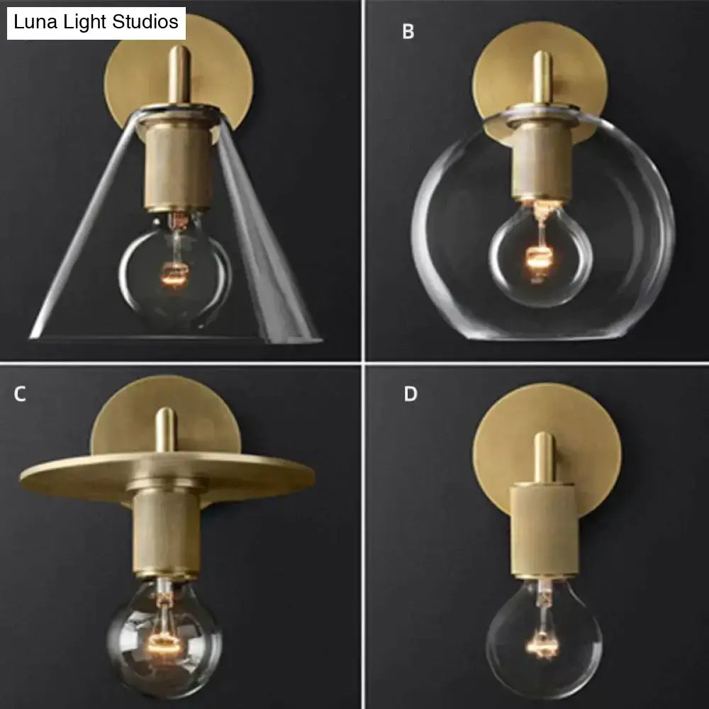 Modern brass and glass wall sconce with gold-toned finish, clear glass shade, and exposed bulb for bedroom lighting