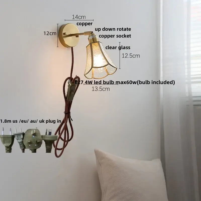 Modern brass and gray glass led wall sconce with copper-finished arm and clear glass led shade for bedroom lighting