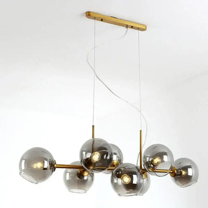 Modern brass pendant lights with spherical bulbs and gray glass pendant shades for kitchen and dining room lighting