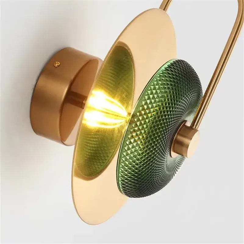 Modern brass and green glass metal wall art lamp with curved arm and concentric circular shades for living room wall art