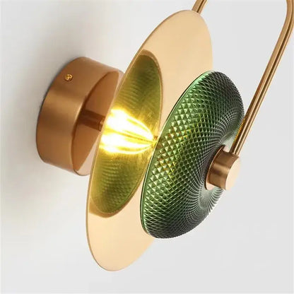 Modern brass and green glass metal wall art lamp with curved arm and concentric circular shades for living room wall art