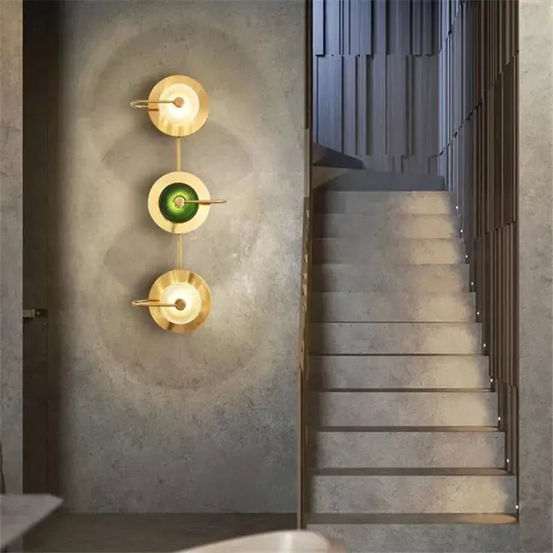Modern brass and green glass metal wall art lamp with three circular gold-toned metal wall sconces for living room