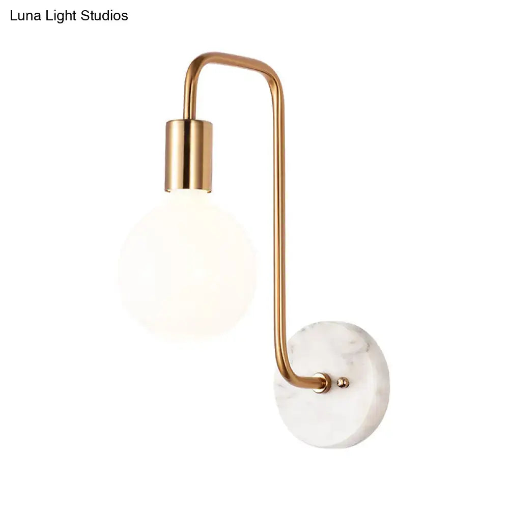 Modern brass and marble wall lamp featuring a white glass sconce with a brass arm and marble base plate for bedroom use