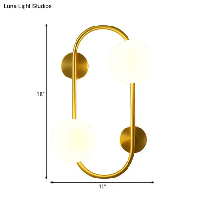Modern brass and milk glass led wall mount lamp with gold-toned curved frame and two frosted glass globe shades