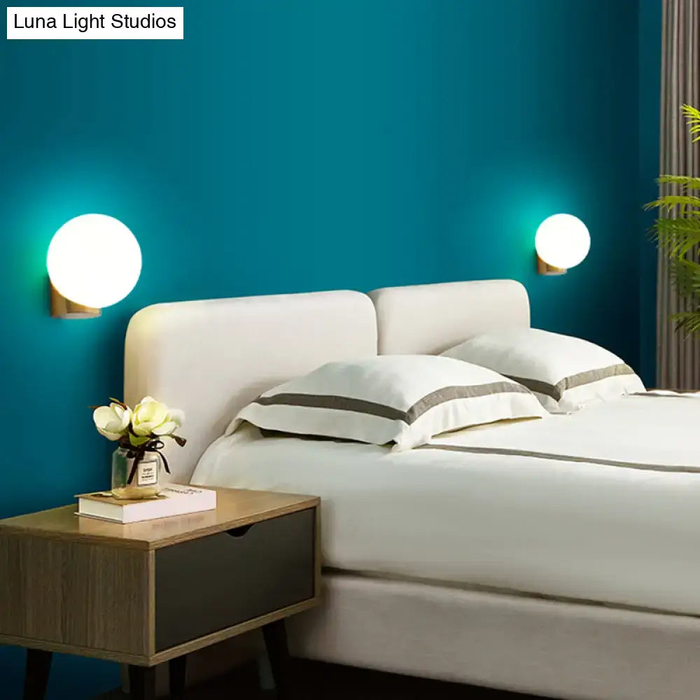 Modern brass and opal glass wall mount lamp with round glowing white sconces for bedside bedroom use