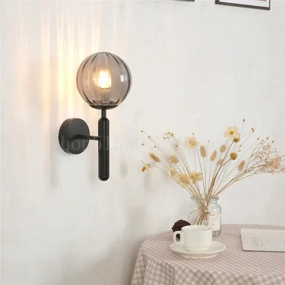 Modern brass wall lamp with sleek black mount and smoky glass globe for living room decorbites blue glass balls