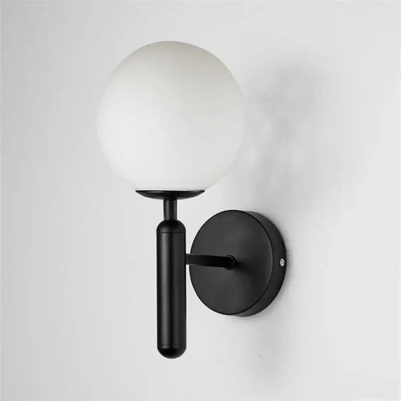 Modern brass and pink glass wall sconce with black spherical frosted globe and matte metal arm for bedroom decorbites blue glass