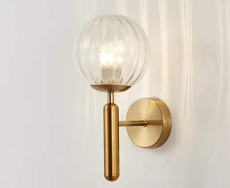Modern brass and pink glass wall sconce with clear ribbed globe and brass components for bedroom decorbites blue glass balls