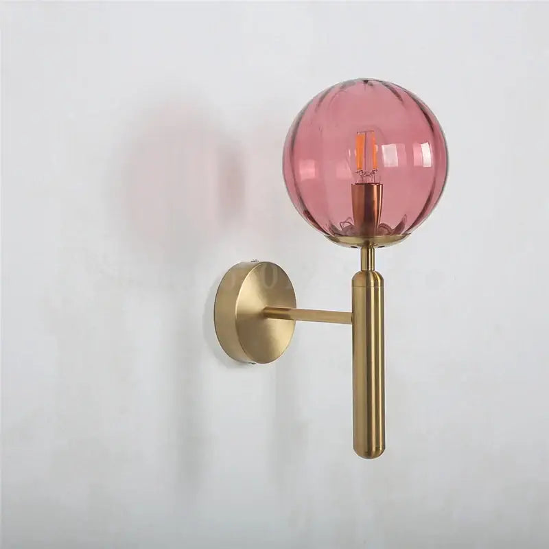 Modern brass wall sconce with translucent pink glass globe and exposed filament bulb for bedroom decorbites blue glass style