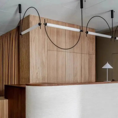 Modern brass and polished chrome pendant light with sleek black curved arms and white glass shades for dining room