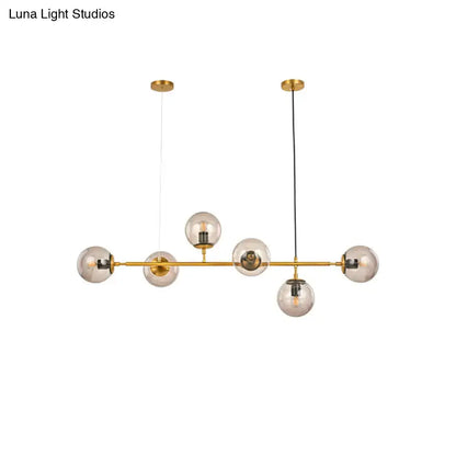 Gold-toned modern bubble chandelier lighting with six smoke gray glass globes suspended from horizontal bar