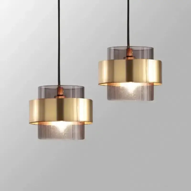 Modern brass and smoked glass pendant light with stacked shades featuring decorbites gold wrought iron design