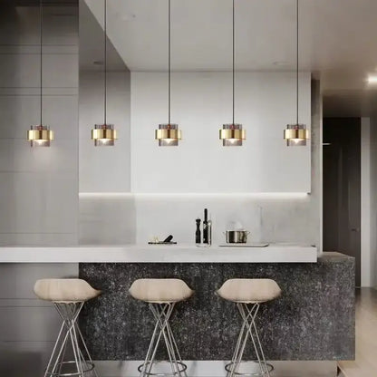 Five modern pendant lights with gold wrought iron cylindrical shades and clear glass accents for dining room decorbites gold wrought